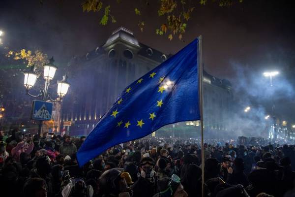 Quelle: Quelle Juda Khatia Psuturi.jpg Menschenmenge bei Nacht mit wehender Europaflagge vor einem beleuchteten historischen Gebäude
